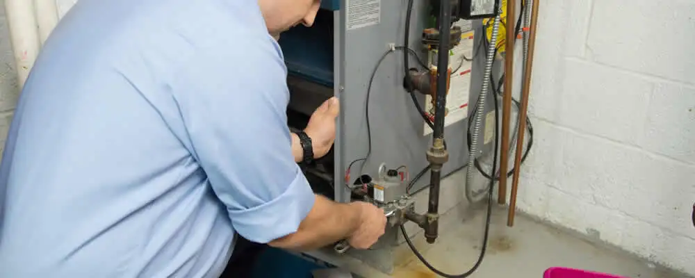 Furnace repair technician inspecting and servicing a home heating system in Omaha, NE