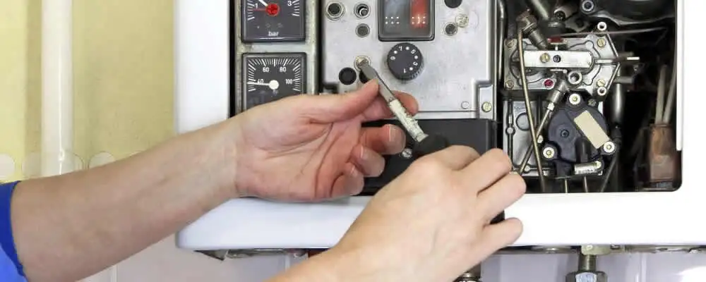 Heating repair technician adjusting boiler controls and components in Omaha, NE