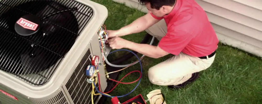 HVAC technician servicing an outdoor air conditioner unit in Omaha, NE