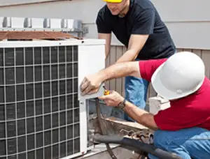 HVAC technicians repairing an outdoor AC unit on a rooftop in Omaha, NE