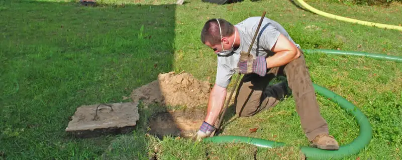 Septic pumping technician servicing a residential septic tank in Omaha, NE