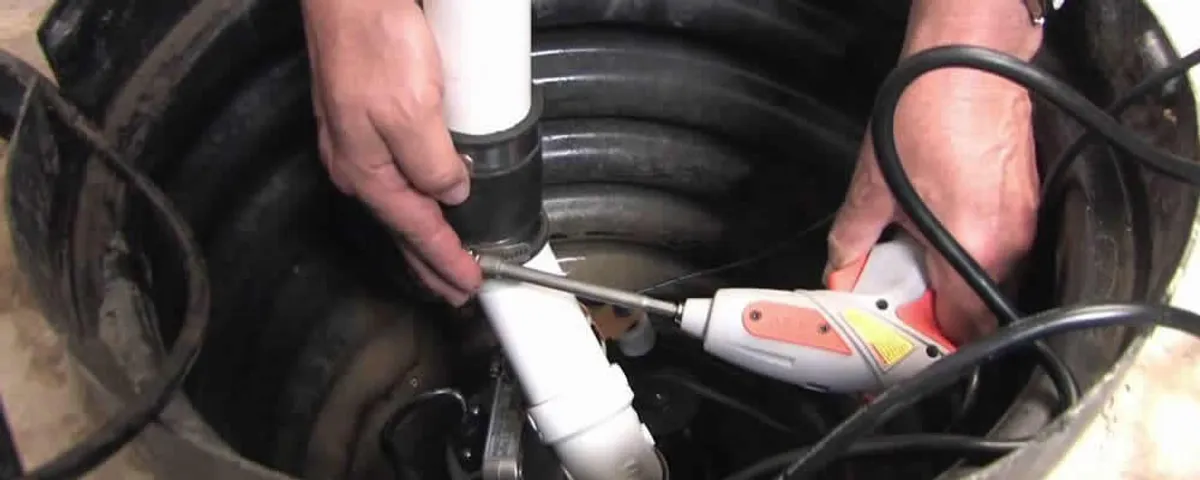 Sump pump installation technician connecting PVC discharge piping in Omaha, NE